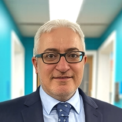 Dentist Aaron Kohan Smiling In Light Blue Room